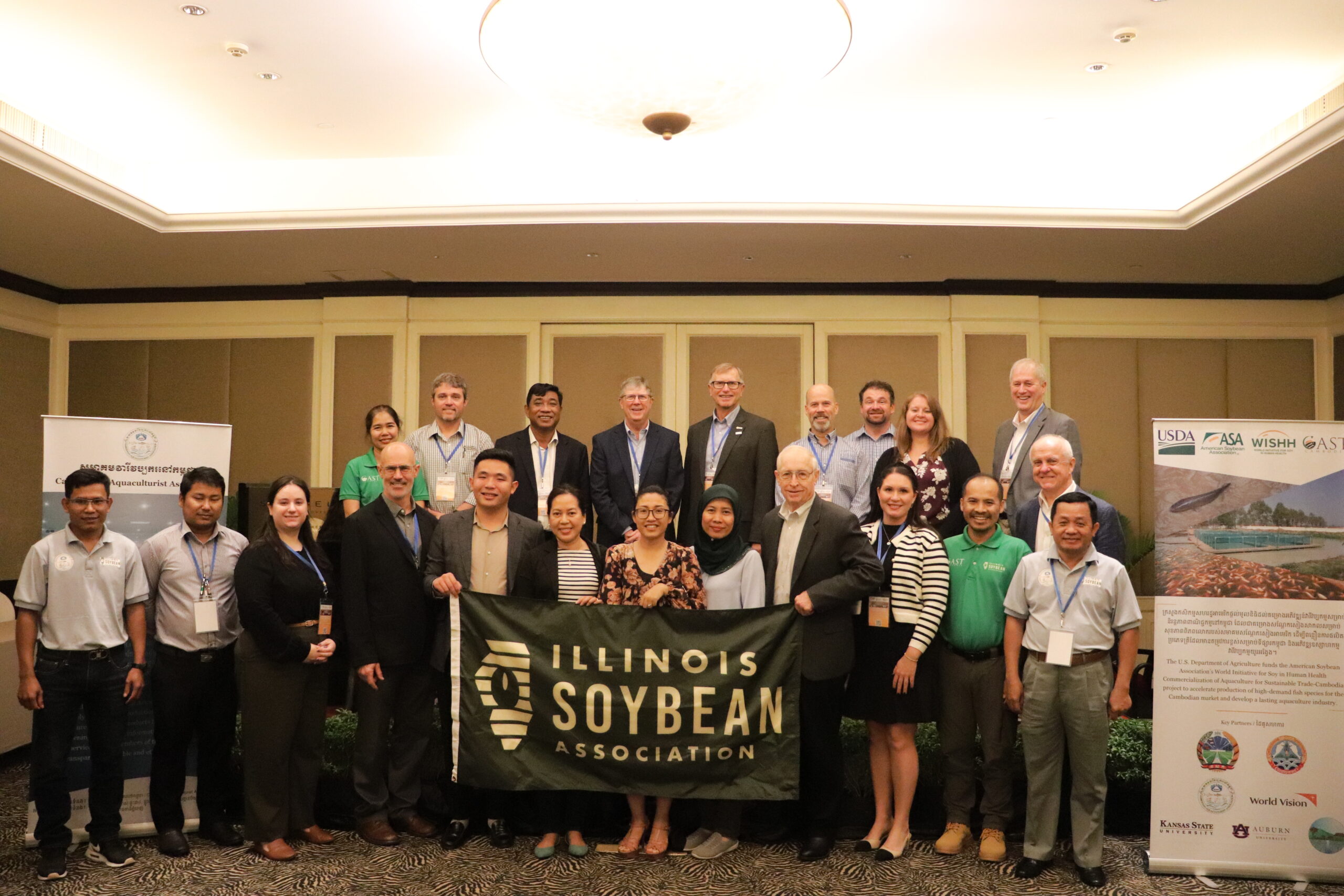 Members of ISA, CAST, and CAA meet with banners bearing each delegation’s respective logos. 