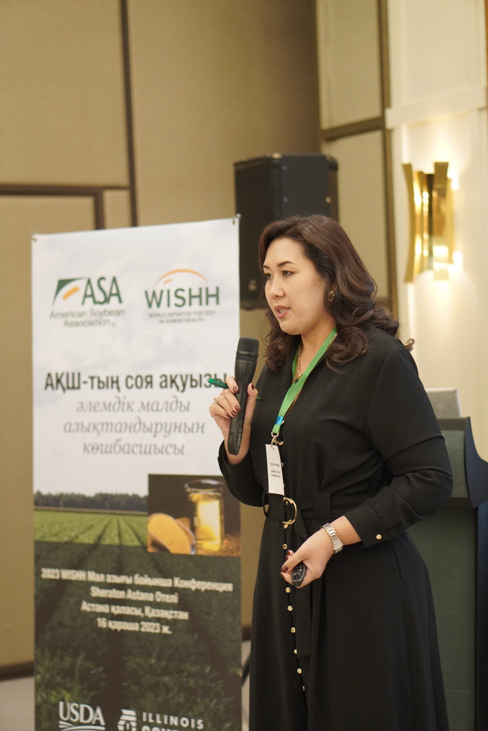 A presenter for the WISHH program stands in front of a poster as she addresses the audience.