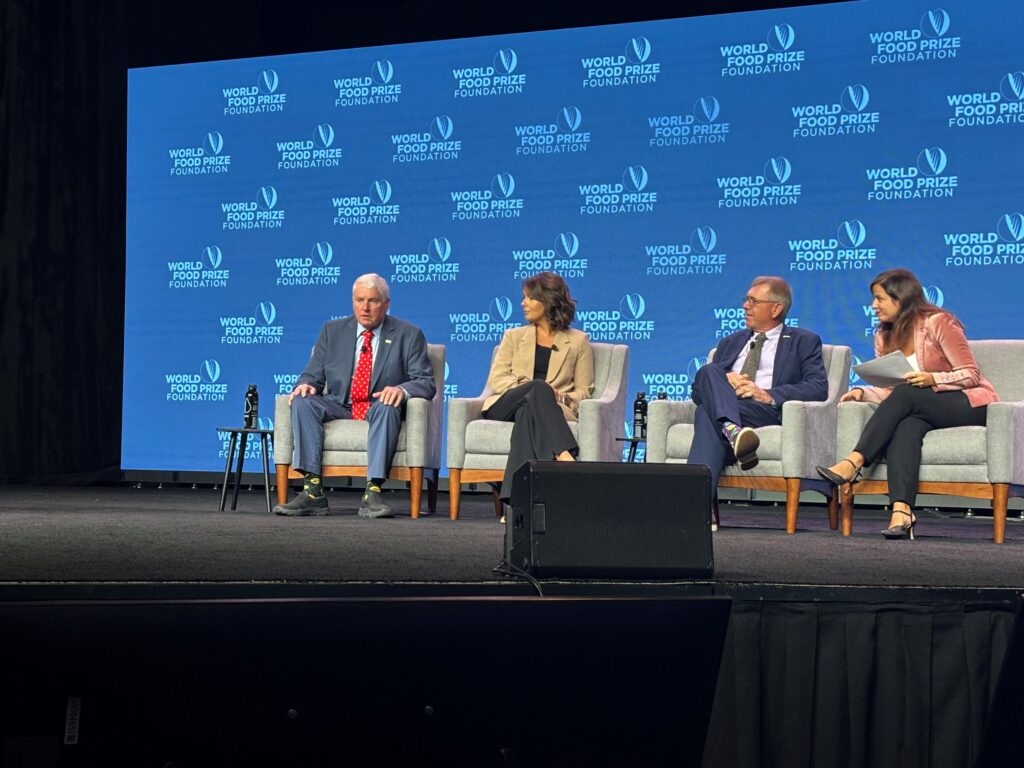 People sitting in chairs on stage.