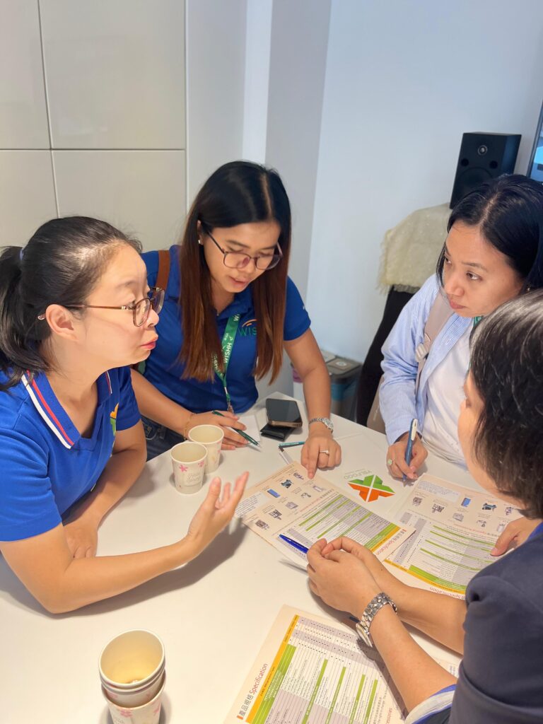 People standing around a table reviewing papers.