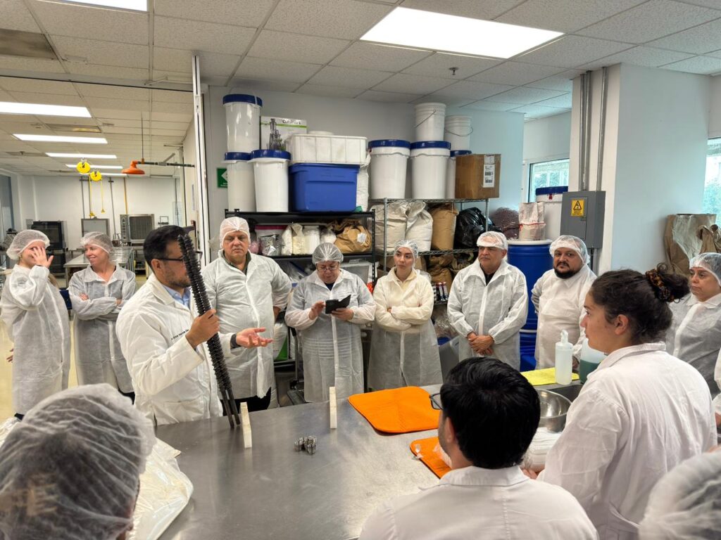People standing around a table in a laboratory learning from an instructor.