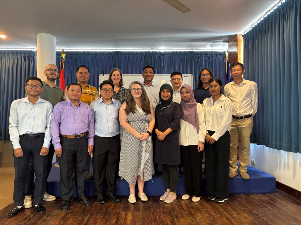 A group of men and women stand together for a group photo.