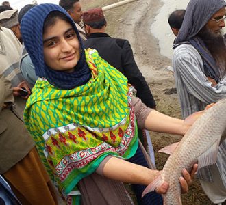 Woman Holding Fish - Case Study Pakistan