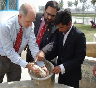 Three men inspecting Soy feed in Pakistan case study